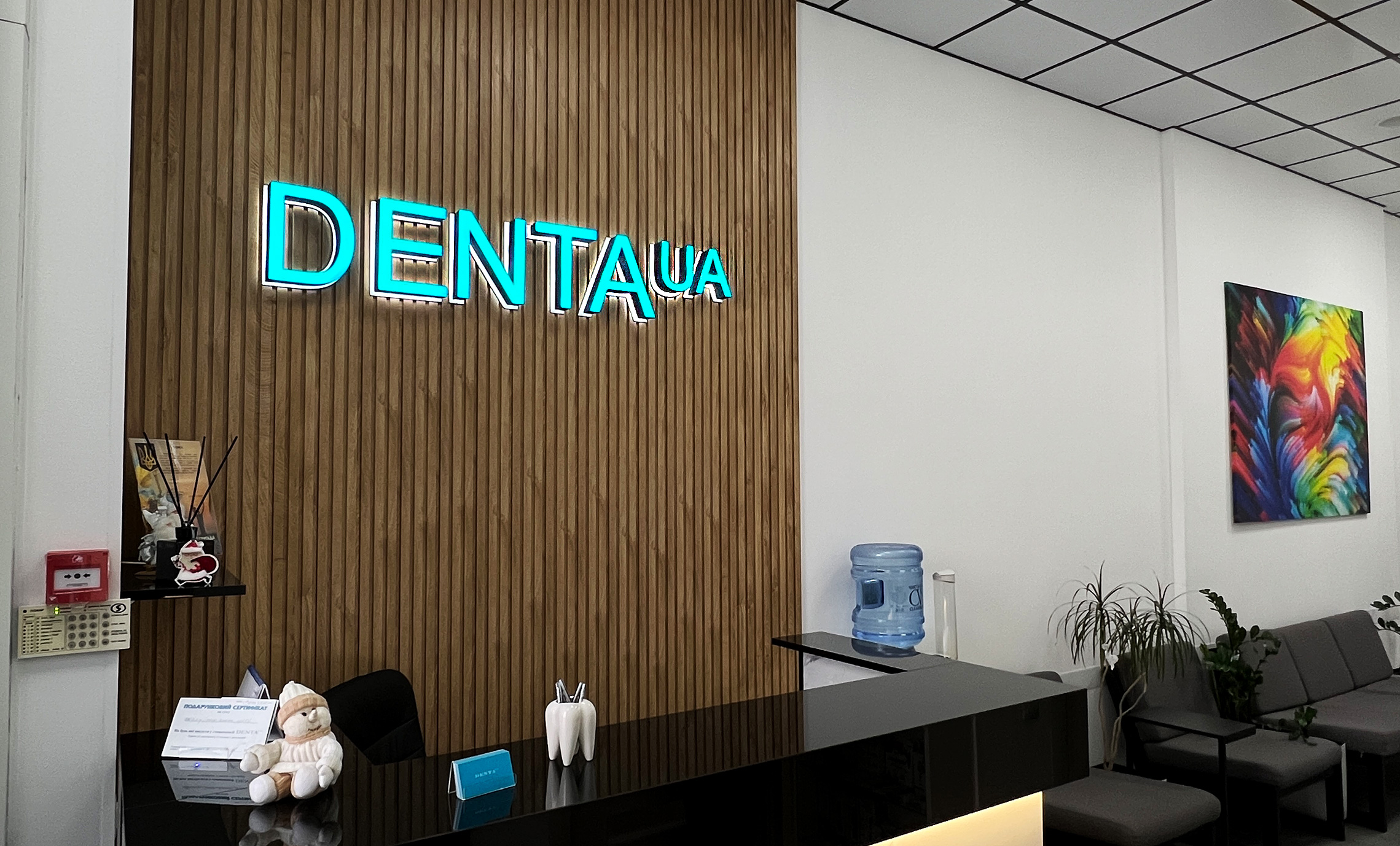 Світловий логотип стоматології на ресепшн приклад