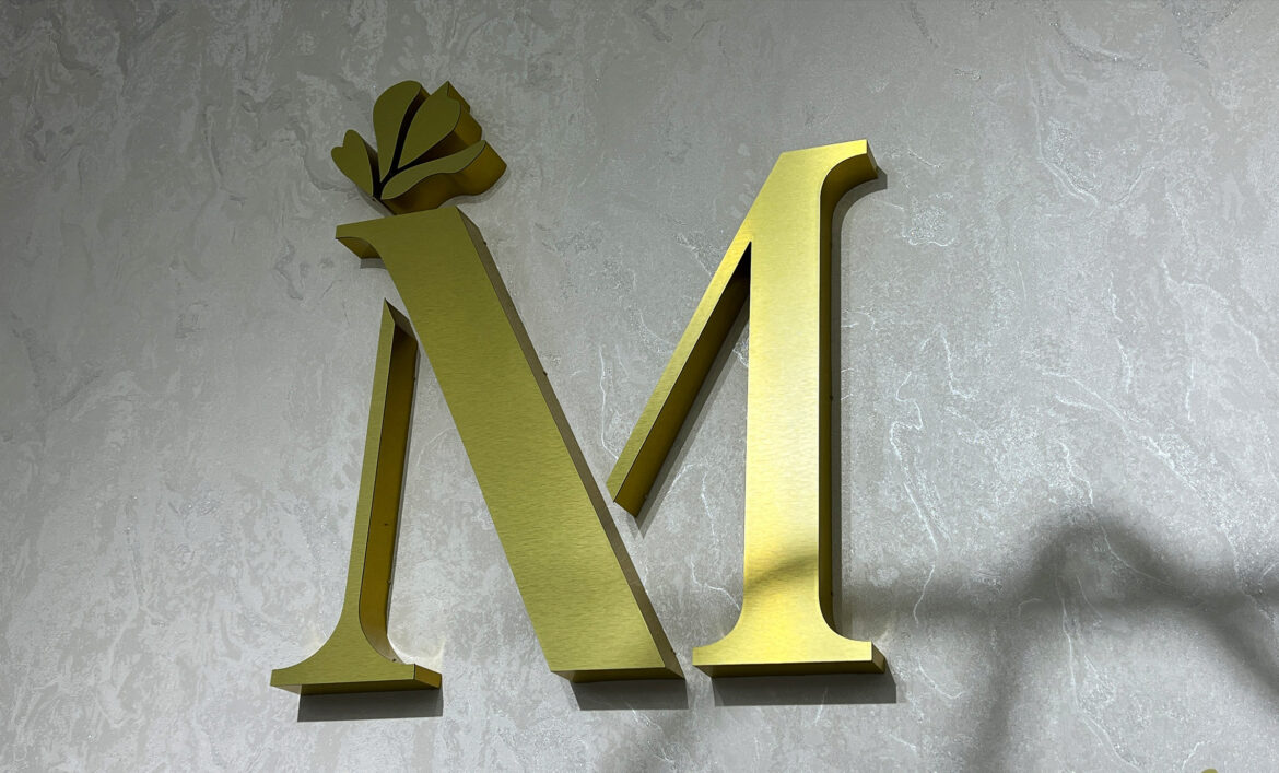 Объемный золотой логотип на стене фото