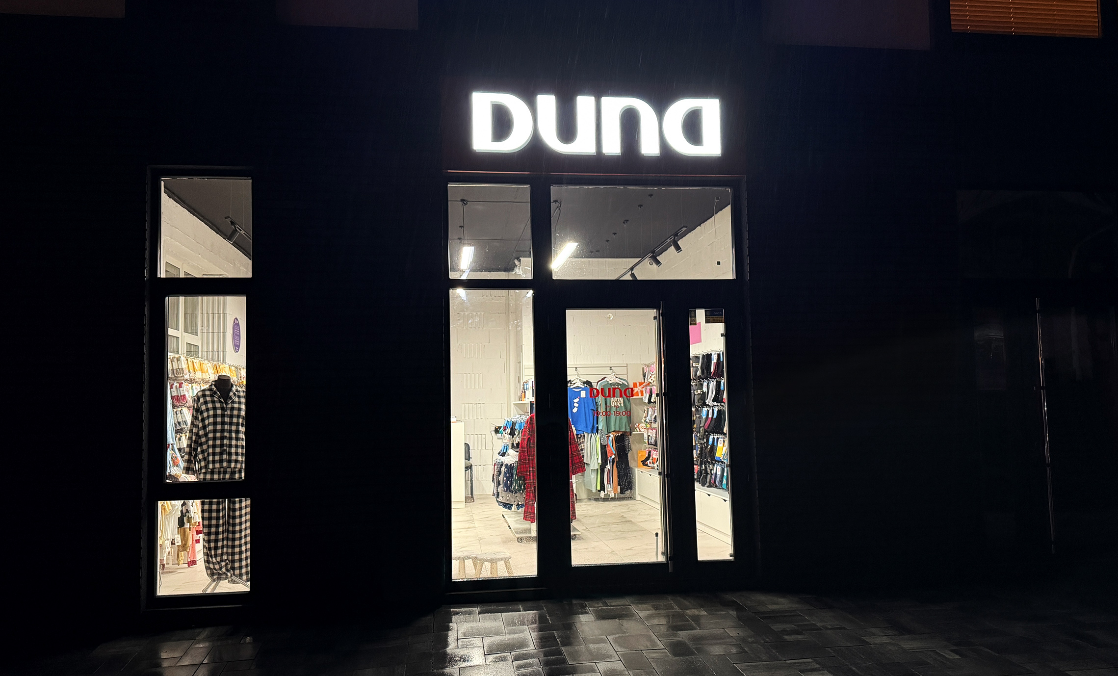 Світловий логотип на вході в магазин фото