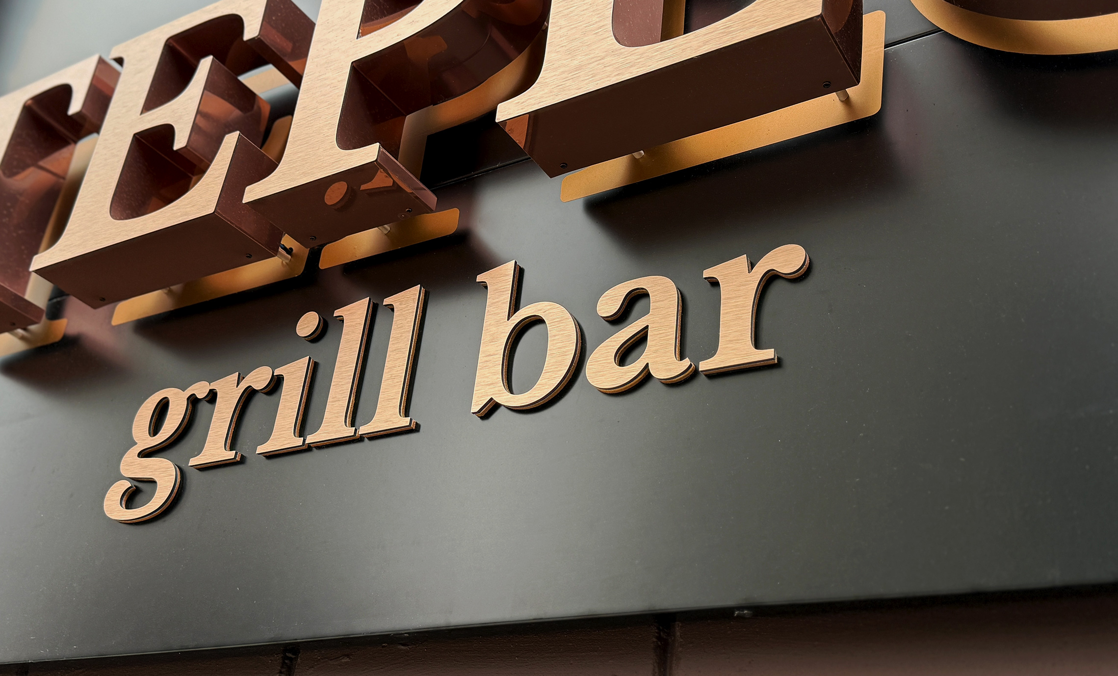 Мідні літери на вивісці фото